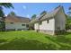 View of the home's backyard showing the house with grassy lawn and trees at 820 Old Cordesville Rd, Moncks Corner, SC 29461