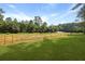 Spacious backyard with lush green grass and farm land in the distance at 820 Old Cordesville Rd, Moncks Corner, SC 29461