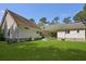 View of the home's backyard showing the house with grassy lawn and trees at 820 Old Cordesville Rd, Moncks Corner, SC 29461