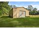 Exterior view of tan metal barn with roll up door and green lawn at 820 Old Cordesville Rd, Moncks Corner, SC 29461