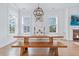 Bright dining room features a trestle table, wood bench, and modern chandelier lighting at 840 Forrest Dr, Charleston, SC 29492