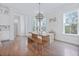 Open-concept dining area with a wooden table and bench seating, next to the modern, white kitchen at 840 Forrest Dr, Charleston, SC 29492