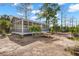 Exterior view of a screened structure, featuring picnic tables and seating, set in a natural surrounding by a lagoon at 840 Forrest Dr, Charleston, SC 29492