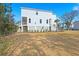 View of a two-story home with light blue siding, white trim, a screened-in porch, and a well-kept lawn at 840 Forrest Dr, Charleston, SC 29492