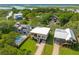 Aerial view showcasing charming waterfront homes surrounded by lush greenery and a tranquil pool at 1012 E Erie Ave, Folly Beach, SC 29439