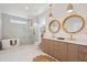 This luxurious bathroom features double sinks, stylish mirrors, and a free-standing tub in the tiled shower at 1012 E Erie Ave, Folly Beach, SC 29439