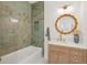 Stylish bathroom featuring a tiled shower, wooden vanity, and a decorative mirror at 1012 E Erie Ave, Folly Beach, SC 29439