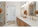 Bright bathroom with double sinks, gold fixtures, and a glass-enclosed shower at 1012 E Erie Ave, Folly Beach, SC 29439