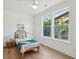 Cozy bedroom with a rattan headboard, palm tree view, and bright natural light at 1012 E Erie Ave, Folly Beach, SC 29439