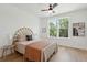Sunlit bedroom with a bamboo-style headboard, hardwood floors, and an inviting window view at 1012 E Erie Ave, Folly Beach, SC 29439