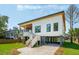 Modern home with elevated design, wood accents, driveway, and well-maintained landscaping at 1012 E Erie Ave, Folly Beach, SC 29439