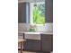 Kitchen sink featuring a farmhouse style sink, stone countertops, modern faucet, and large picture window at 1012 E Erie Ave, Folly Beach, SC 29439
