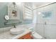 This is a light and bright bathroom with a vessel sink, walk-in shower with white subway tiles, and a unique mirror at 104 Beach St, Mount Pleasant, SC 29464