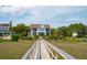 Beautiful coastal home with direct access via a wooden walkway and lush landscaping at 104 Beach St, Mount Pleasant, SC 29464