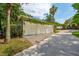 A three-car garage with creeping vines, a paver driveway, and landscaping at 104 Beach St, Mount Pleasant, SC 29464