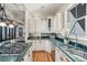 Bright kitchen with stainless steel appliances and green stone countertops overlooking an open living space at 104 Beach St, Mount Pleasant, SC 29464