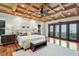 This is a well-staged primary bedroom with dark wood floors, bright white walls, and large glass doors to a balcony at 104 Beach St, Mount Pleasant, SC 29464