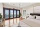 A bright main bedroom with access to a balcony overlooking the water, hardwood floors, and bright white walls at 104 Beach St, Mount Pleasant, SC 29464