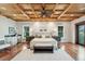 This main bedroom features a coffered ceiling with fan, hardwood floors, and a small wet bar with white cabinets at 104 Beach St, Mount Pleasant, SC 29464