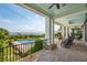 Beautiful covered outdoor area with brick floors, ceiling fans, rocking chairs, and a glimpse of the ocean at 104 Beach St, Mount Pleasant, SC 29464