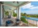 Inviting covered outdoor space with brick floors, ceiling fans, rocking chairs, and a view of the pool and ocean at 104 Beach St, Mount Pleasant, SC 29464