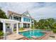 An eye-level view of the rear exterior showing the pool, the house and its balconies, and the covered patio area at 104 Beach St, Mount Pleasant, SC 29464