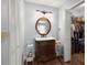 Bathroom with vanity, round mirror, wood-look floors, and storage cabinets at 106 Brown Ct, Summerville, SC 29486