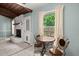 Cozy dining area with decorative table, fireplace, and view to fenced backyard at 106 Brown Ct, Summerville, SC 29486