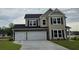 Beautiful two-story home with stone accents, a spacious three-car garage, and a well-manicured lawn at 114 Captains Creek Ln, Ridgeville, SC 29472