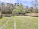 Spacious backyard with partial fencing and various outbuildings on a sunny day at 132 Tranquil Ln, Ladson, SC 29456