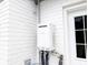 An energy-efficient tankless water heater is installed on the exterior brick wall next to a door at 132 Tranquil Ln, Ladson, SC 29456