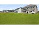 Expansive backyard with lush green grass and neighboring houses in the distance at 133 Headwater Dr, Summerville, SC 29486