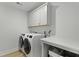 Well-organized laundry room with front-load washer, dryer and ample storage cabinets at 133 Headwater Dr, Summerville, SC 29486