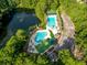 Aerial view of community pools, parking lot, and pond surrounded by trees and landscaping at 1330 Somersby Ln, Mount Pleasant, SC 29466