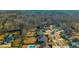 A high angle showing the layout of homes within a community, including a pool, pond, and surrounding forest at 136 Stagecoach Ln, Summerville, SC 29483