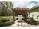 Outdoor kitchen features an outdoor grill beneath a wood pergola, patio and green yard at 136 Stagecoach Ln, Summerville, SC 29483