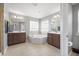 Bathroom featuring double vanities, a tiled floor, a garden tub, and large windows providing plenty of natural light at 136 Stagecoach Ln, Summerville, SC 29483