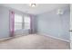 Light and airy bedroom boasts a large window, plush carpeting, and fresh lilac walls at 136 Stagecoach Ln, Summerville, SC 29483