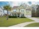 Charming two-story home features a manicured lawn, attached two-car garage, and a beautiful palm tree in the front yard at 136 Stagecoach Ln, Summerville, SC 29483