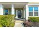 Inviting covered front porch with elegant columns, manicured hedges, and a stylish front door with glass detailing at 136 Stagecoach Ln, Summerville, SC 29483