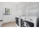 Laundry room with washer, dryer, and wire shelving for organization at 136 Stagecoach Ln, Summerville, SC 29483