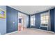 Bright living room with two windows, blue walls, and tan carpet at 136 Stagecoach Ln, Summerville, SC 29483