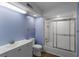 Bathroom with blue walls, white vanity, and a shower/tub with sliding glass doors at 138 W Mariners Cay Dr, Folly Beach, SC 29439