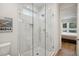 Clean bathroom with a glass shower enclosure featuring white tile and light hardwood floors at 14 F St # B, Charleston, SC 29403