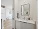 Modern powder room featuring white cabinets, marble counters, and a sleek, rectangular mirror at 14 F St # B, Charleston, SC 29403