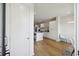 Modern kitchen leading to other rooms, white walls, hardwood floors, and stainless steel appliances at 14 F St # B, Charleston, SC 29403