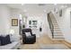 Open-concept living area with hardwood floors, modern staircase, and view into kitchen at 14 F St # B, Charleston, SC 29403