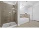 Bathroom featuring glass shower with tile surround, soaking tub, and modern chandelier lighting for a luxurious experience at 145 Pier View St # 407, Charleston, SC 29492