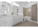 Bathroom featuring dual sinks, white cabinets, tile floors, and a shower-tub combo with a shower curtain at 145 Pier View St # 407, Charleston, SC 29492