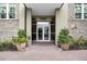 Building entrance with brick walkway, planters, and glass doors leading inside; address is displayed above door at 145 Pier View St # 407, Charleston, SC 29492